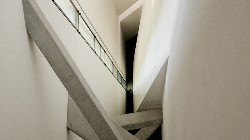 a very long narrow hallway with a metal hand rail